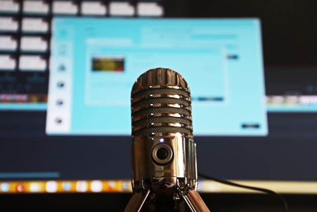 microphone in front of a computer screen for a podcast